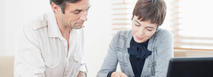 Businesswoman guiding man with paperwork